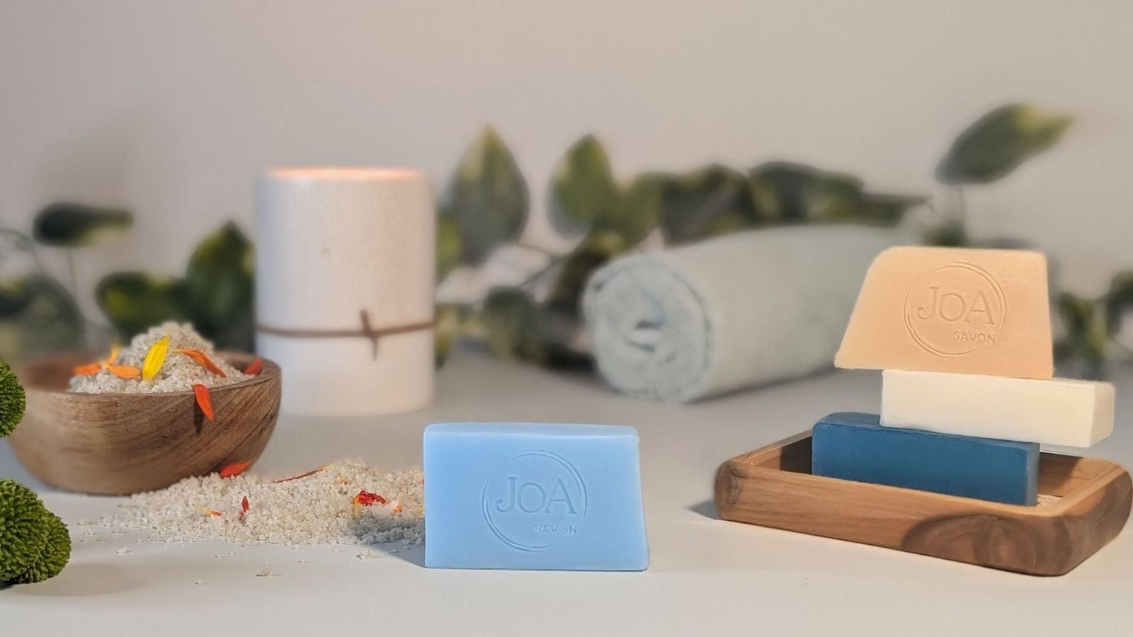 Savons Joa aux couleurs variées, ambiance spa avec sel parfumé et serviette roulée